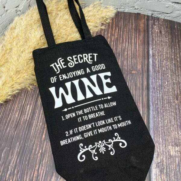 Schwarze Flaschentasche liegend mit lustigem Spruch "The Secret of enjoying a good wine..."