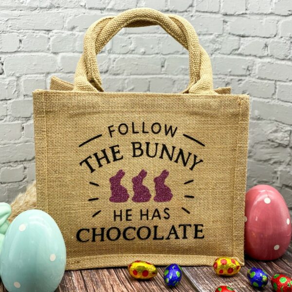 Jutetasche mit Spruch "Follow The Bunny he has the Chocolate" mit drei violetten Glitzerhasen im Farmhousestil