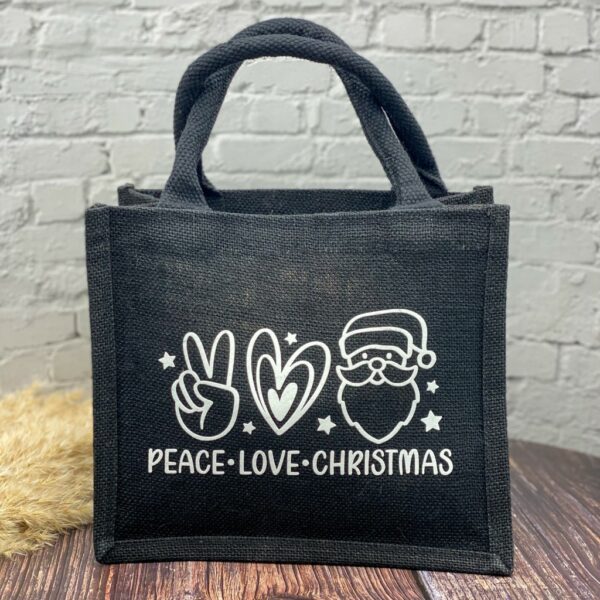 Schwarze Jutetasche mit weissem Aufdruck "Peace - Love - Christmas" und dazugehörenden Symbolen