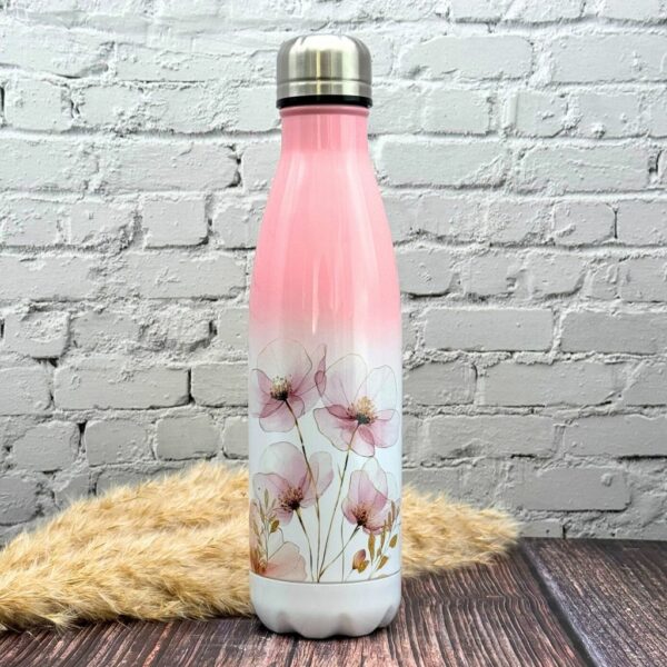 Trinkflasche aus Edelstahl mit Blütenmotiv, stehend auf Holzuntergrund